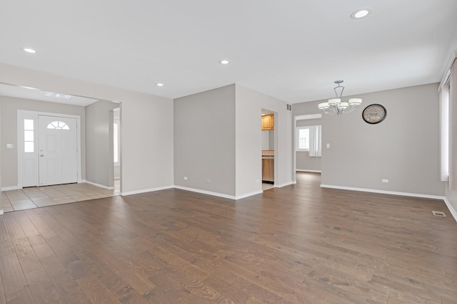 unfurnished living room featuring plenty of natural light, wood finished floors, visible vents, and recessed lighting