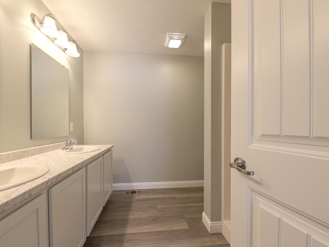 full bathroom featuring visible vents, a sink, and a textured ceiling