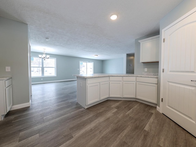 kitchen with white cabinets, a peninsula, light countertops, and open floor plan