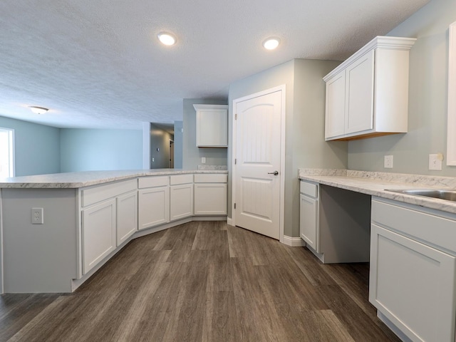 kitchen featuring a peninsula, white cabinetry, and light countertops