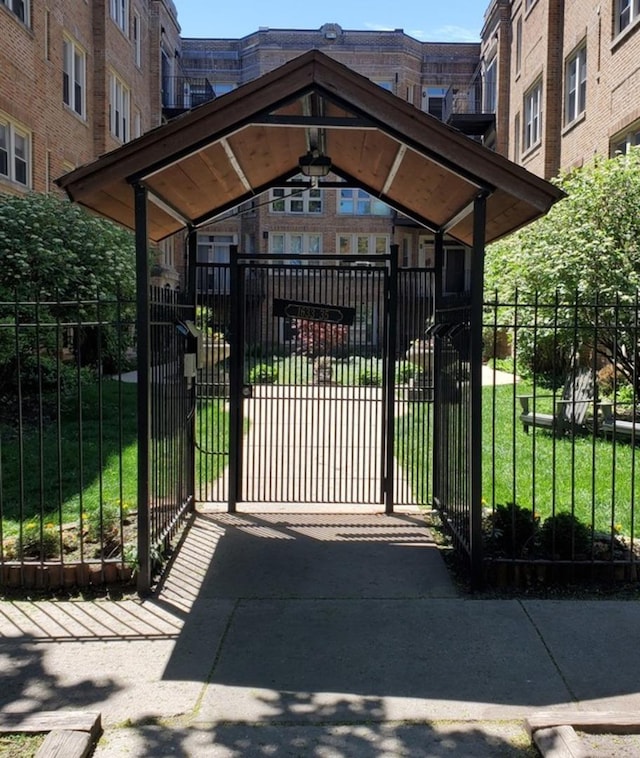 view of gate featuring a lawn and fence