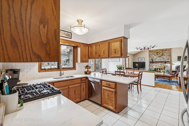 7821 Teton Rd, Orland Park, IL 60462 - kitchen featuring stainless steel dishwasher, a peninsula, open floor plan, tasteful backsplash, and brown cabinetry