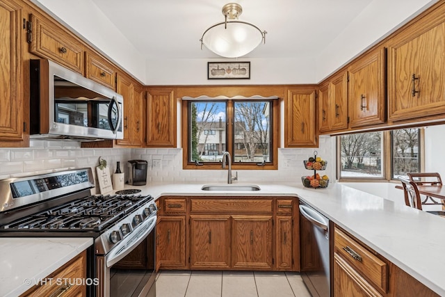 7821 Teton Rd, Orland Park, IL 60462 - kitchen featuring stainless steel appliances, brown cabinetry, decorative backsplash, and light tile patterned floors