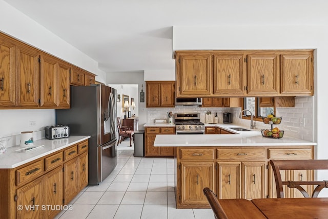 7821 Teton Rd, Orland Park, IL 60462 - kitchen with stainless steel appliances, light countertops, decorative backsplash, a peninsula, and brown cabinets