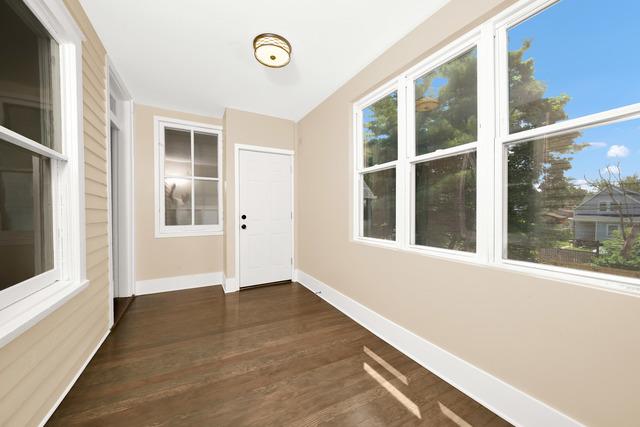 doorway featuring dark wood-type flooring, a wealth of natural light, and baseboards