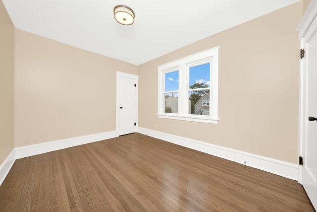 spare room featuring baseboards and wood finished floors