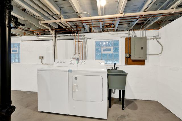 clothes washing area with laundry area, electric panel, and separate washer and dryer