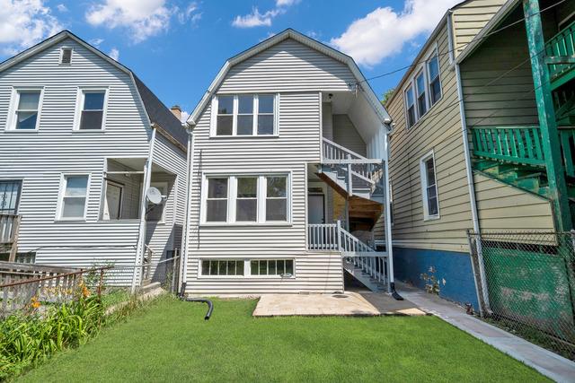 rear view of house featuring a yard, a patio area, fence, and a gambrel roof