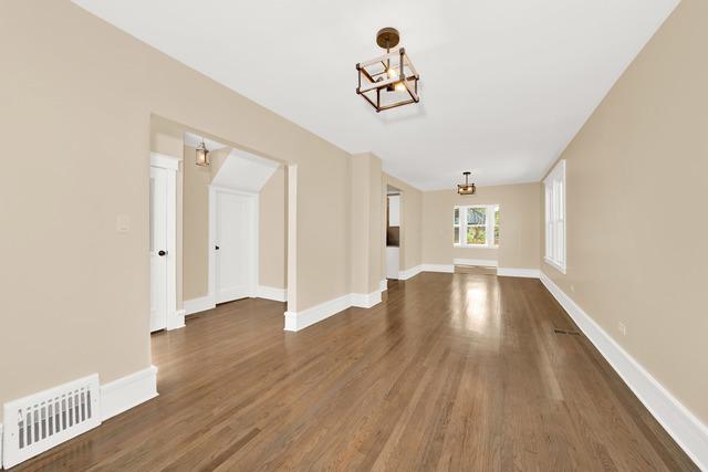 interior space with dark wood finished floors, visible vents, and baseboards