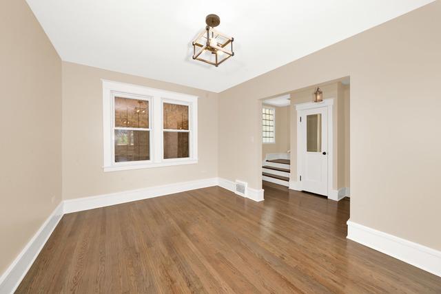 unfurnished room with a chandelier, visible vents, dark wood finished floors, and baseboards