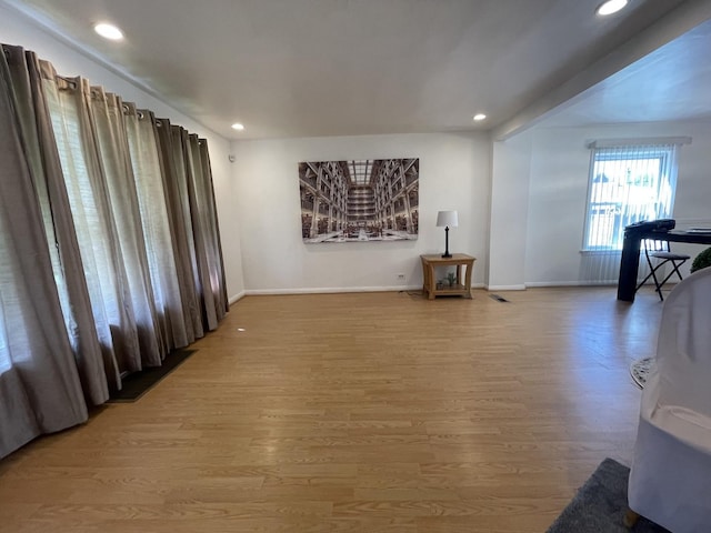 living room with visible vents, baseboards, wood finished floors, and recessed lighting