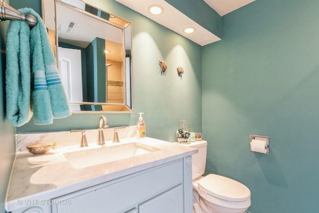 bathroom featuring toilet, recessed lighting, visible vents, and vanity