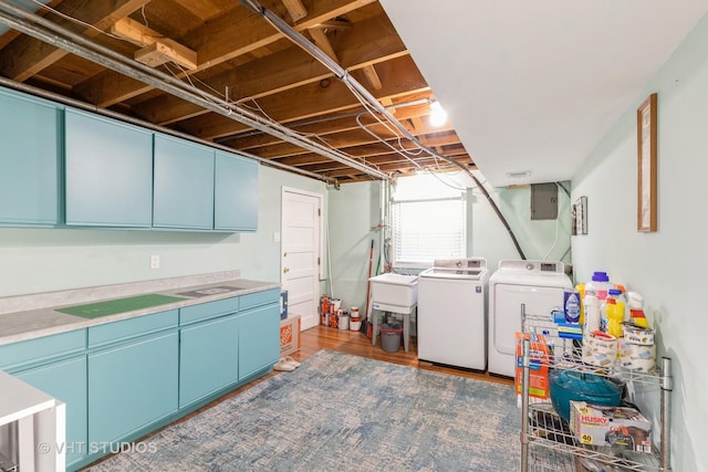 washroom with separate washer and dryer, wood finished floors, cabinet space, and electric panel