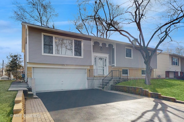 bi-level home featuring brick siding, a front lawn, an attached garage, and driveway