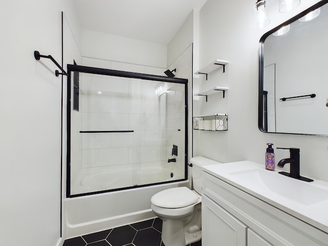 full bathroom with combined bath / shower with glass door, vanity, toilet, and tile patterned floors