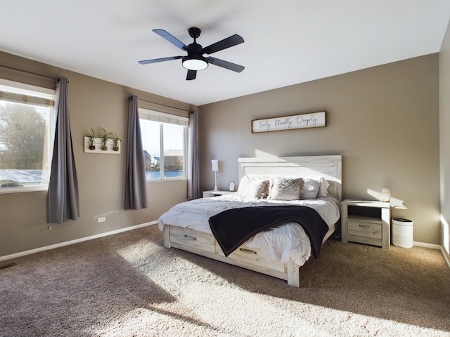 carpeted bedroom with ceiling fan and baseboards