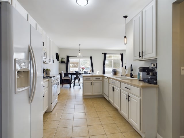 kitchen featuring light tile patterned floors, a peninsula, white appliances, a sink, and white cabinets