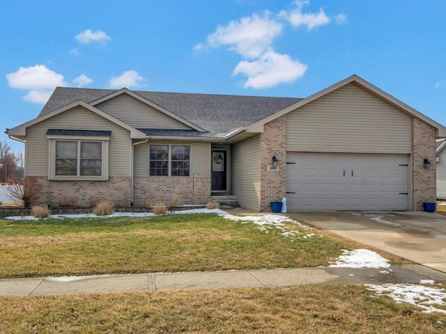 view of front of house with a front yard, concrete driveway, brick siding, and an attached garage