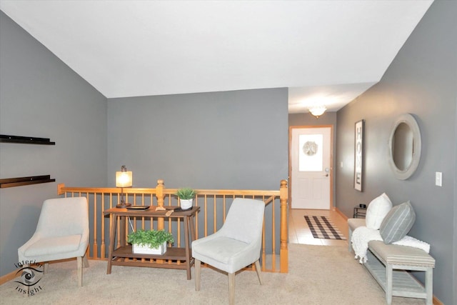 living area featuring light carpet, vaulted ceiling, an upstairs landing, and light tile patterned floors