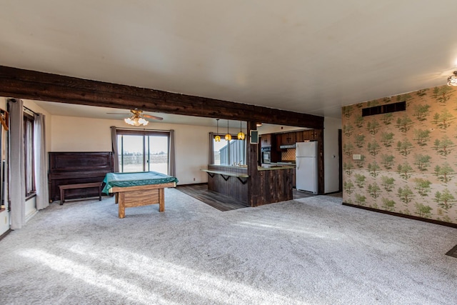 recreation room with dark colored carpet, beamed ceiling, visible vents, and wallpapered walls