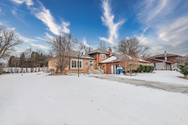 tri-level home featuring an attached garage and a chimney