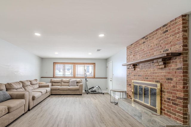 living room with light wood-style floors, recessed lighting, a fireplace, and baseboards