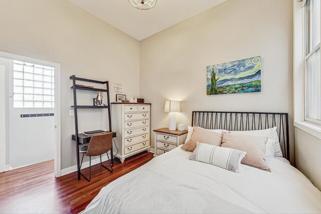 bedroom featuring baseboards and dark wood finished floors