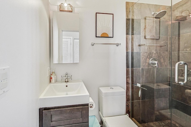 bathroom featuring a shower stall, toilet, and vanity