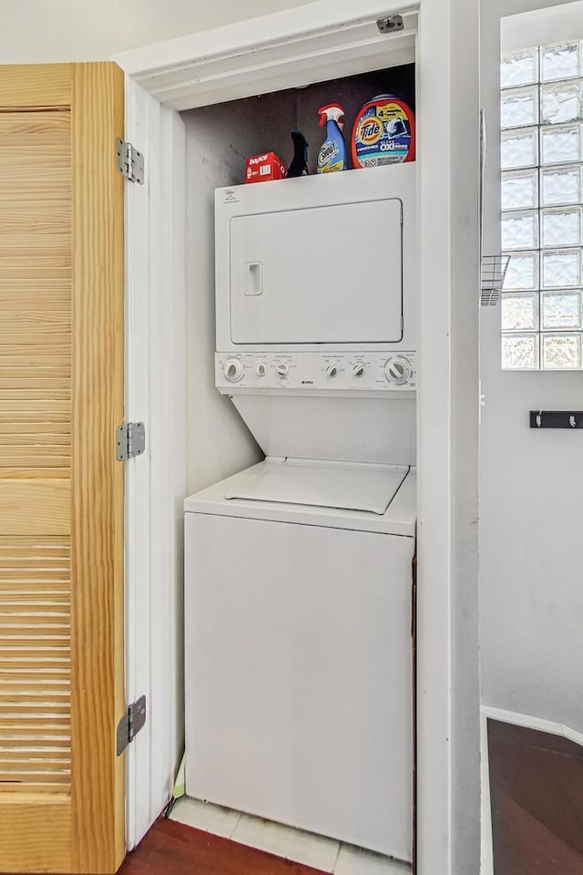 clothes washing area with stacked washer / drying machine and laundry area