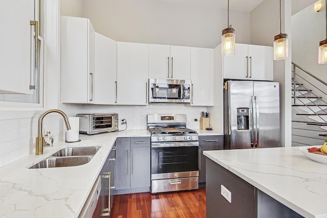 kitchen with tasteful backsplash, dark wood-type flooring, a toaster, stainless steel appliances, and a sink