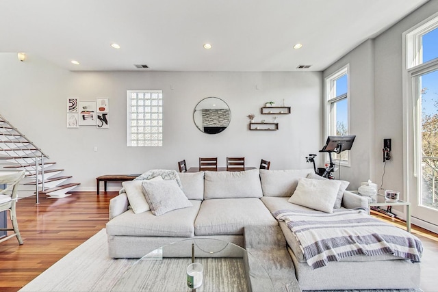 living room featuring a wealth of natural light, visible vents, and wood finished floors