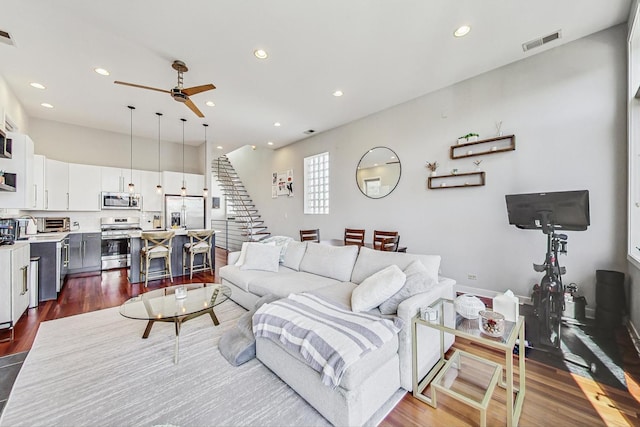 living area with visible vents, a ceiling fan, dark wood-style floors, recessed lighting, and stairway