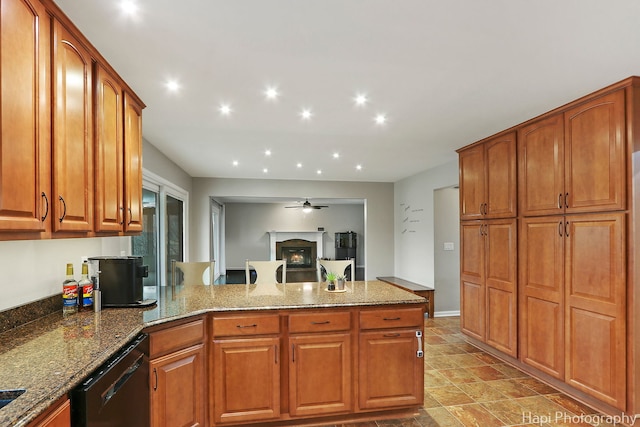 kitchen with black dishwasher, stone countertops, a glass covered fireplace, a peninsula, and recessed lighting