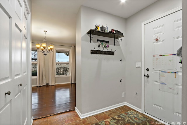 foyer featuring an inviting chandelier and baseboards