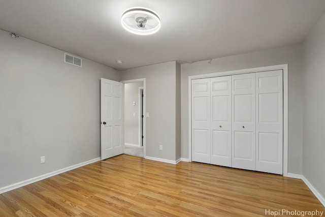 unfurnished bedroom featuring visible vents, light wood-style flooring, and baseboards