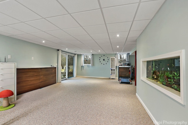 unfurnished living room featuring baseboards, a drop ceiling, carpet, and recessed lighting