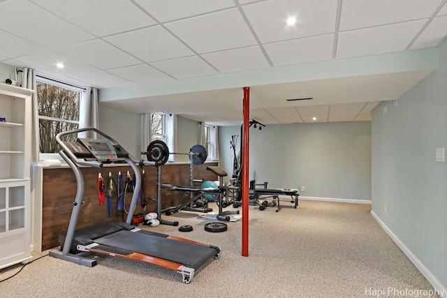 exercise room with carpet, baseboards, and a drop ceiling