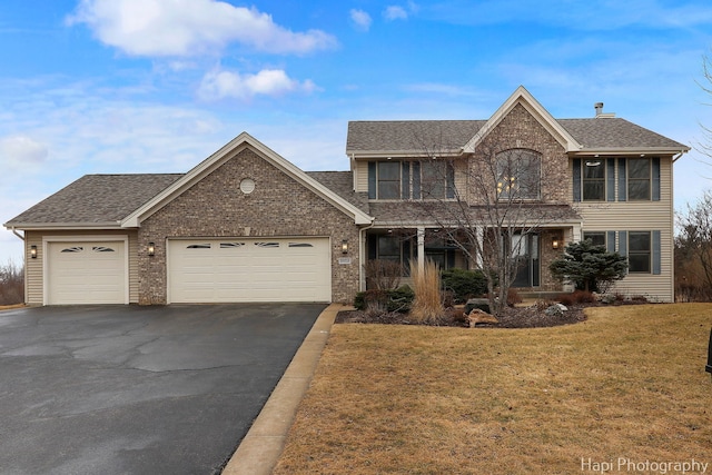 view of front of house featuring a garage, a shingled roof, aphalt driveway, and a front yard