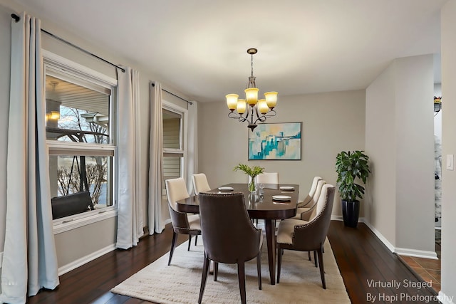 dining space featuring a notable chandelier, dark wood finished floors, and baseboards