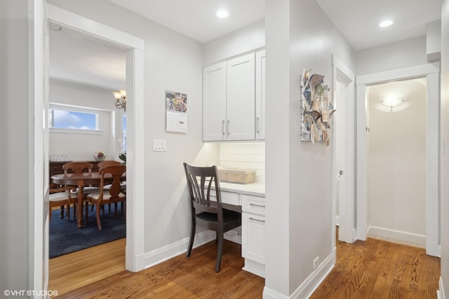 hallway with recessed lighting, light wood-type flooring, and baseboards