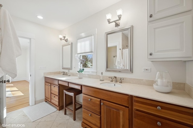 bathroom with recessed lighting, a sink, and double vanity