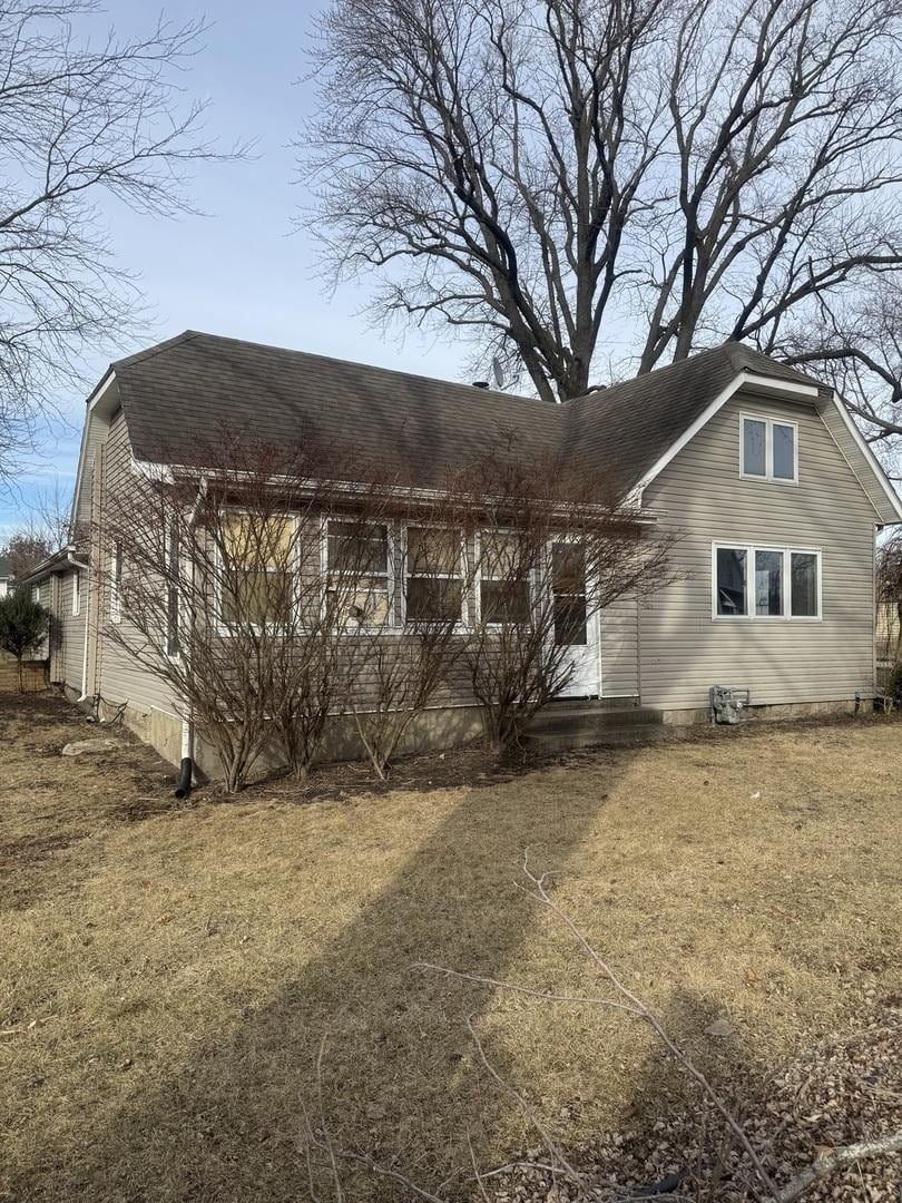 view of front of property with a front lawn and roof with shingles