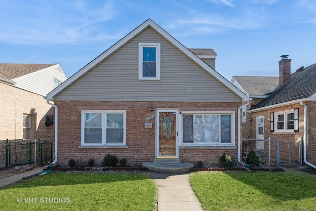 bungalow-style home with brick siding, a front lawn, and fence