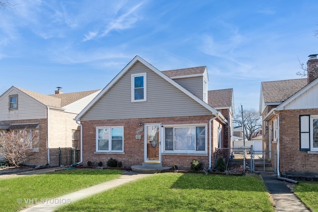 view of front of home with brick siding, roof with shingles, a gate, fence, and a front yard