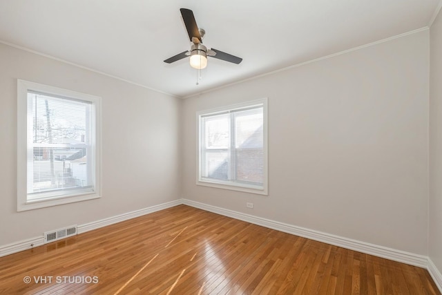 unfurnished room with ornamental molding, light wood-type flooring, visible vents, and baseboards