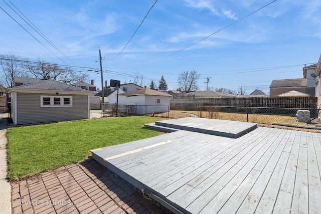 wooden deck featuring a fenced backyard, a lawn, and an outdoor structure