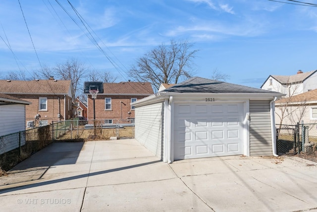 detached garage featuring driveway and fence