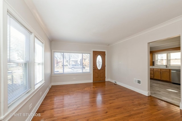 foyer entrance featuring ornamental molding, light wood finished floors, visible vents, and baseboards