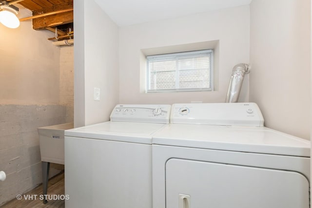 washroom featuring laundry area, washer and clothes dryer, and wood finished floors