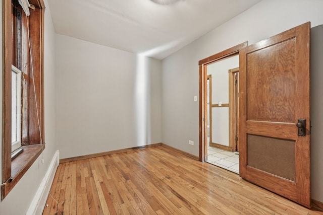 empty room with light wood-type flooring and baseboards